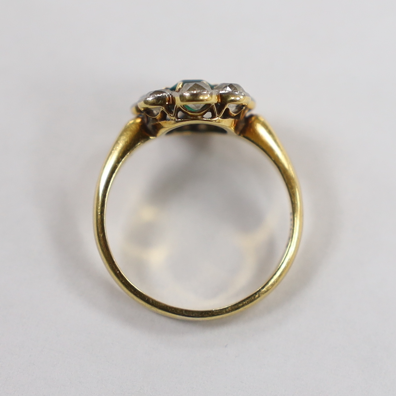 An 18ct, emerald and diamond set circular cluster ring, size L, gross weight 3.3 grams.